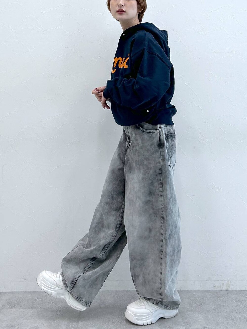 ブルー系のパーカー、ブラック系のデニムパンツを着用したレディースの春コーディネートの5枚目の写真