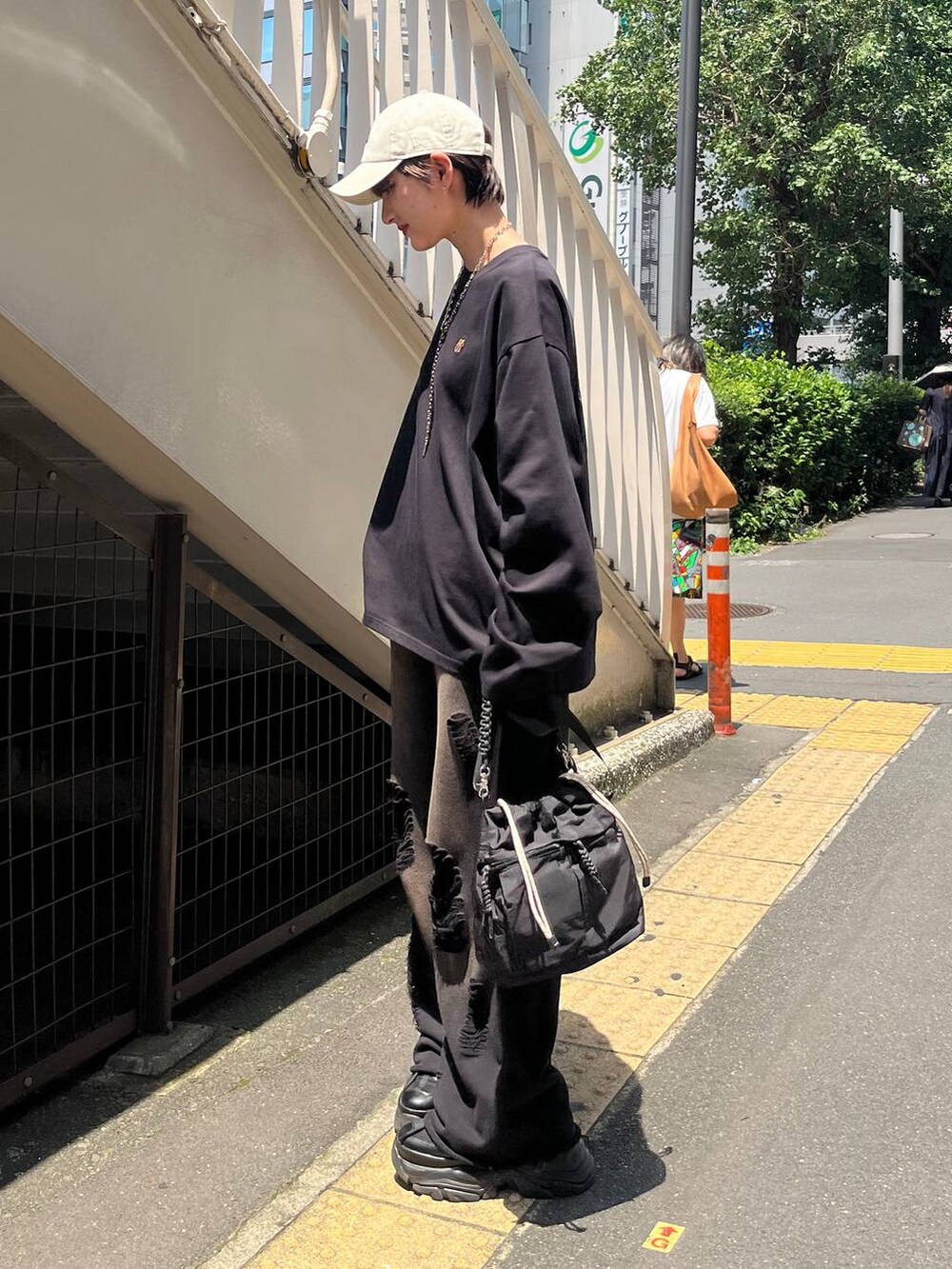 ブラック系のショルダーバッグ、ブラック系のスニーカー、ブラック系のスウェットパンツを着用したレディースの秋コーディネートの4枚目の写真