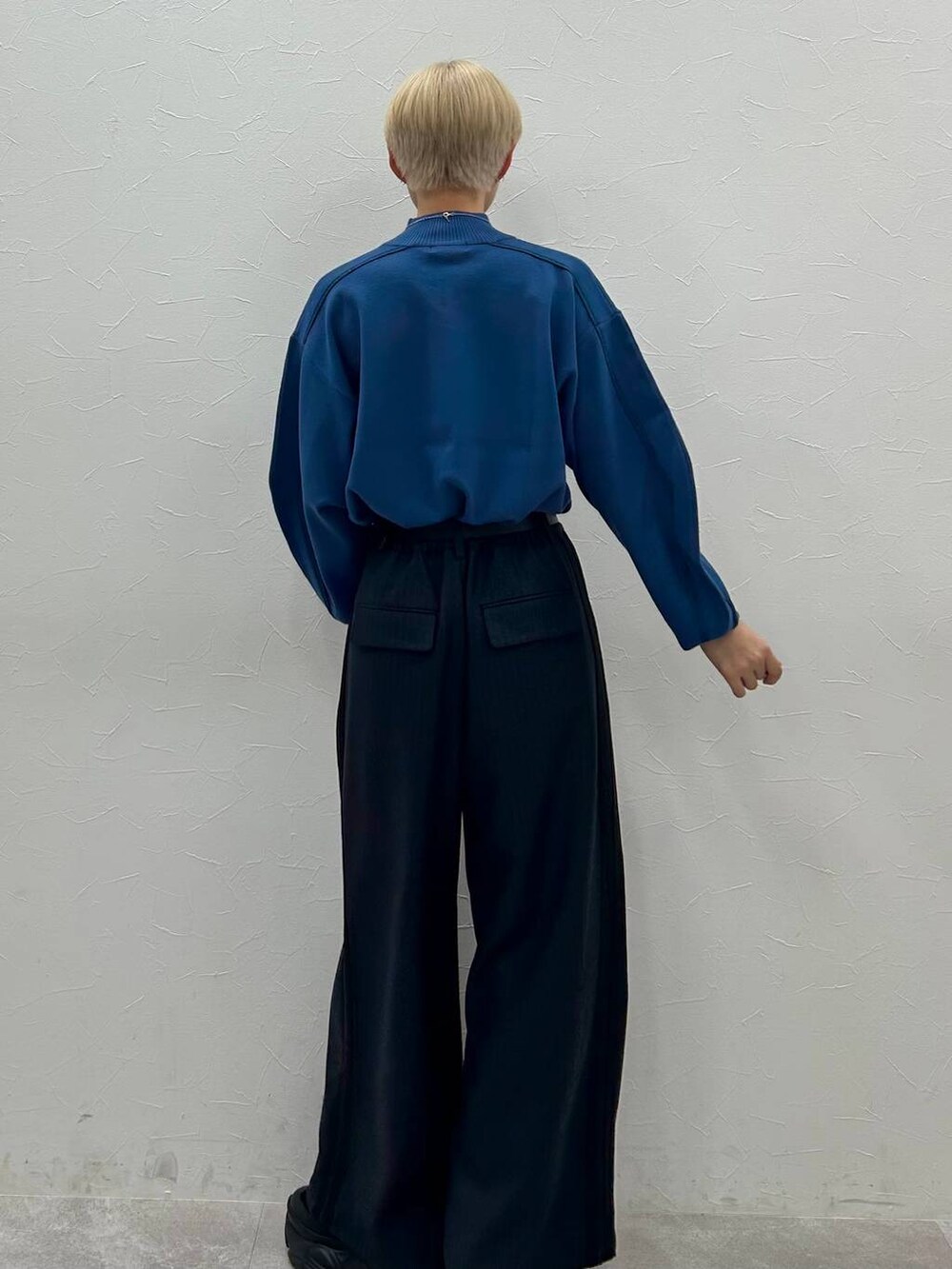 ブラック系のスニーカー、ブルー系のニット/セーター、ブラック系のスラックスを着用したレディースの秋コーディネートの6枚目の写真