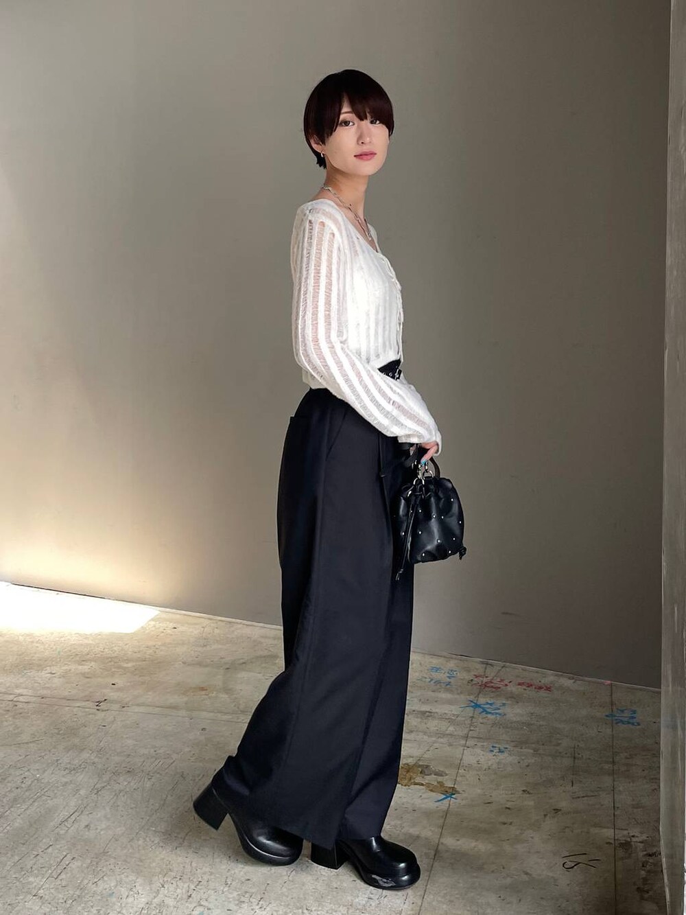 ホワイト系のキャミソール、ブラック系のショルダーバッグ、ホワイト系のカーディガン/ボレロを着用したレディースの冬コーディネートの6枚目の写真