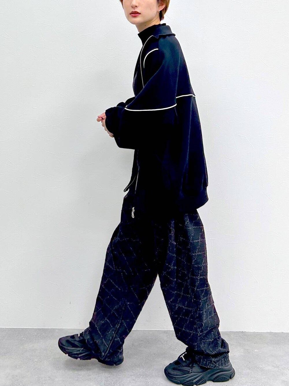 ブラック系のスウェット、ブラック系のデニムパンツ、ブラック系のベルトを着用したレディースの冬コーディネートの5枚目の写真