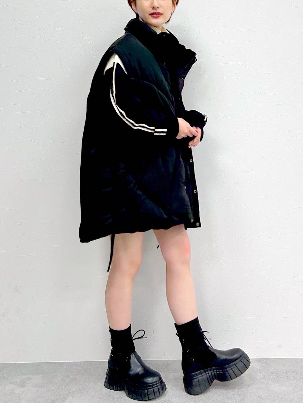 ブラック系のブルゾン、ブラック系のブーツ、ブラック系のスカートを着用したレディースの冬コーディネートの4枚目の写真