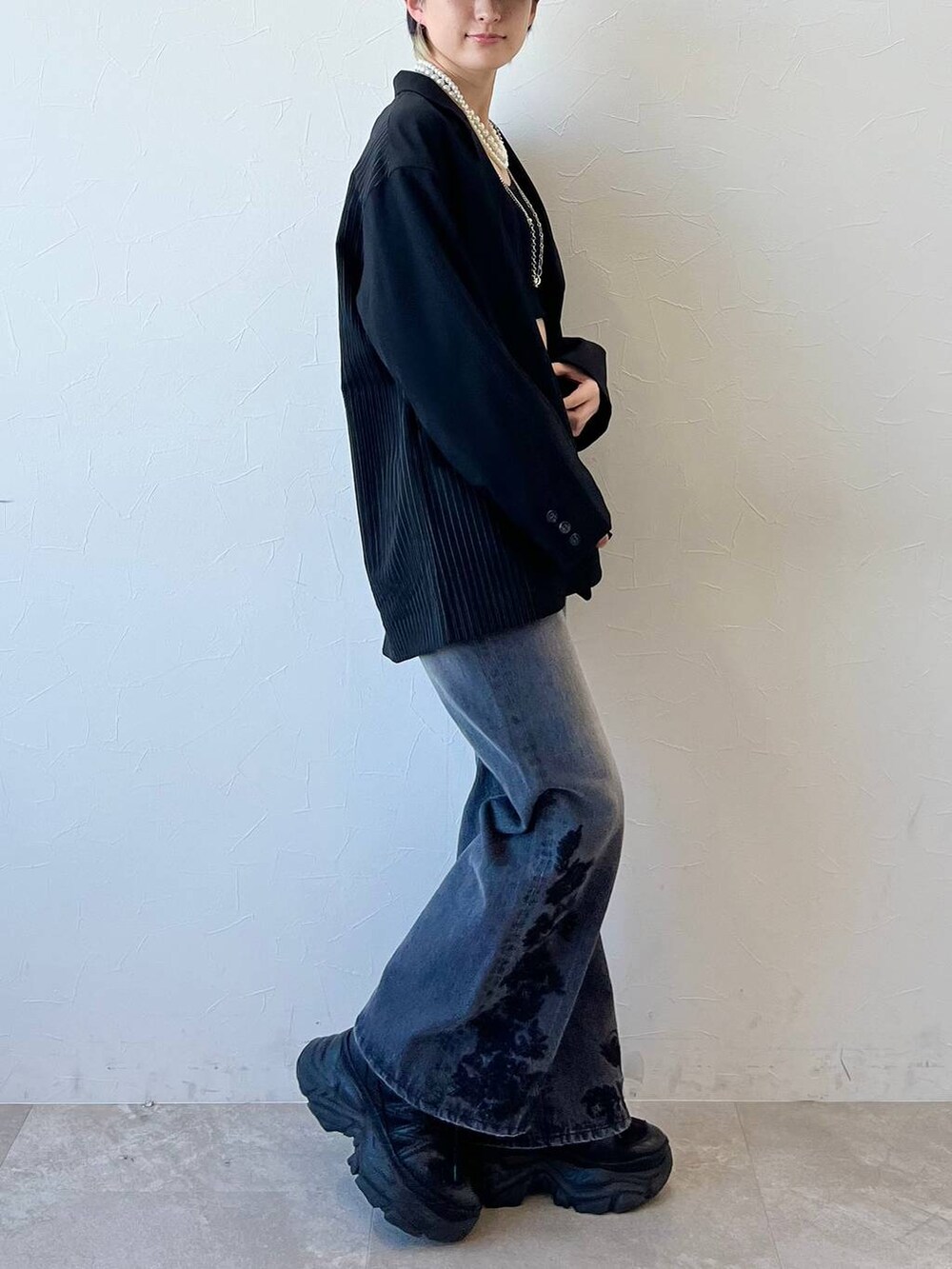 ブラック系のスニーカー、ブラック系のキャミソール、ブラック系のテーラードジャケットを着用したレディースの春コーディネートの6枚目の写真