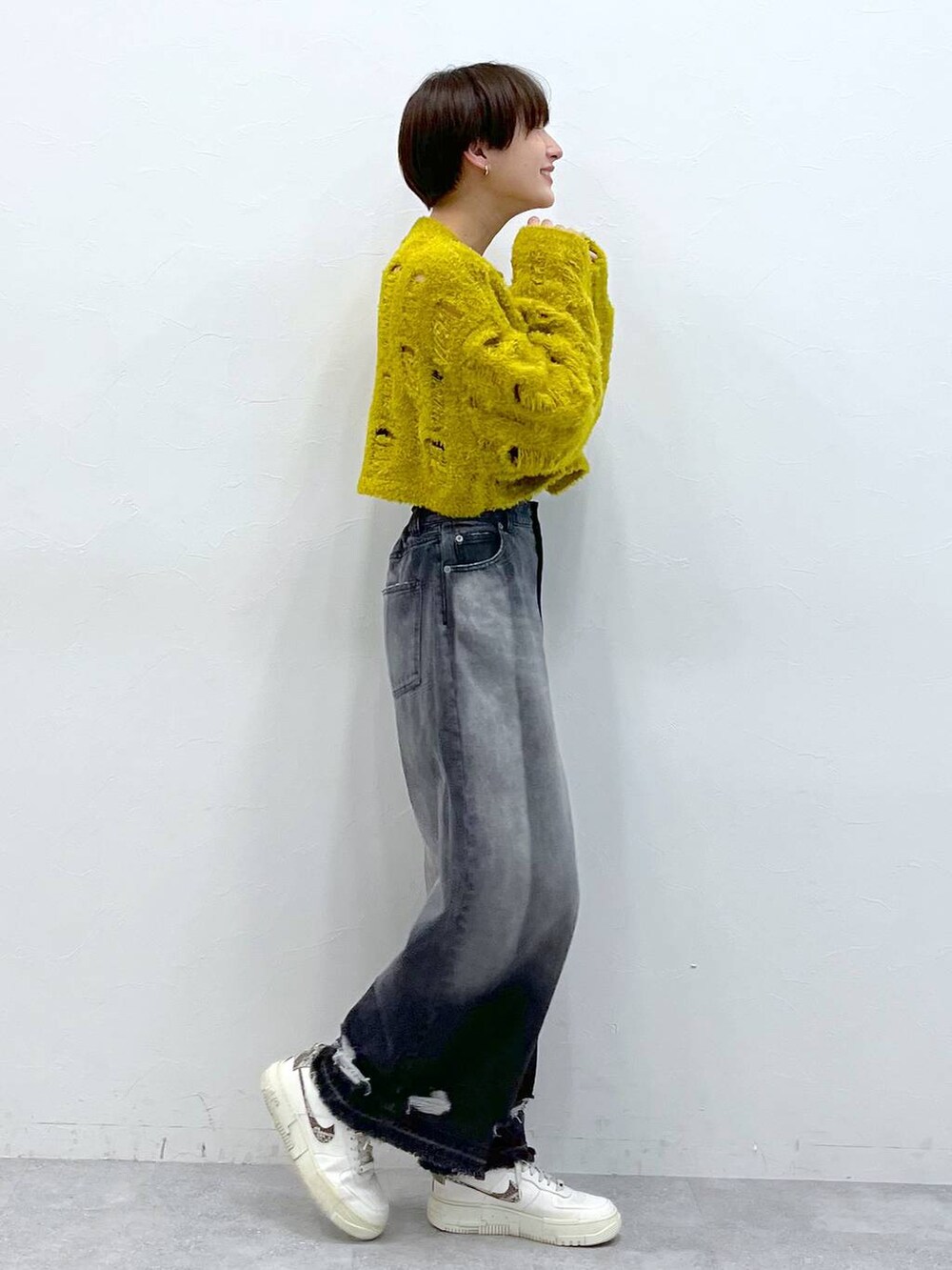 ブラック系のデニムパンツ、イエロー系のニット/セーターを着用したレディースの秋コーディネートの4枚目の写真