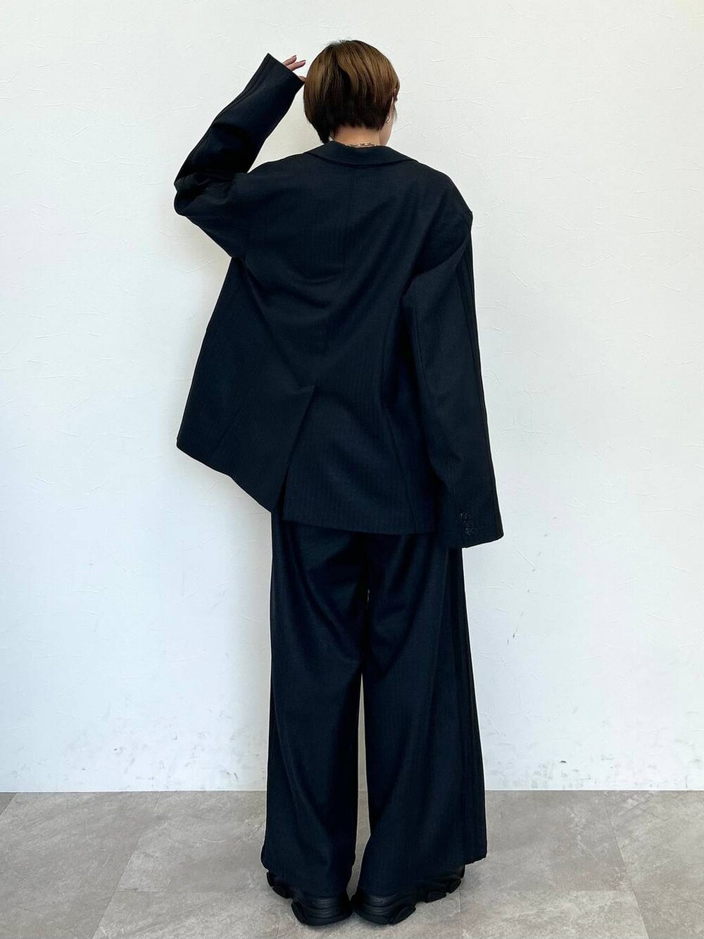 ブラック系のスラックス、ブラック系のテーラードジャケット、ブラック系のベルトを着用したレディースの秋コーディネートの6枚目の写真