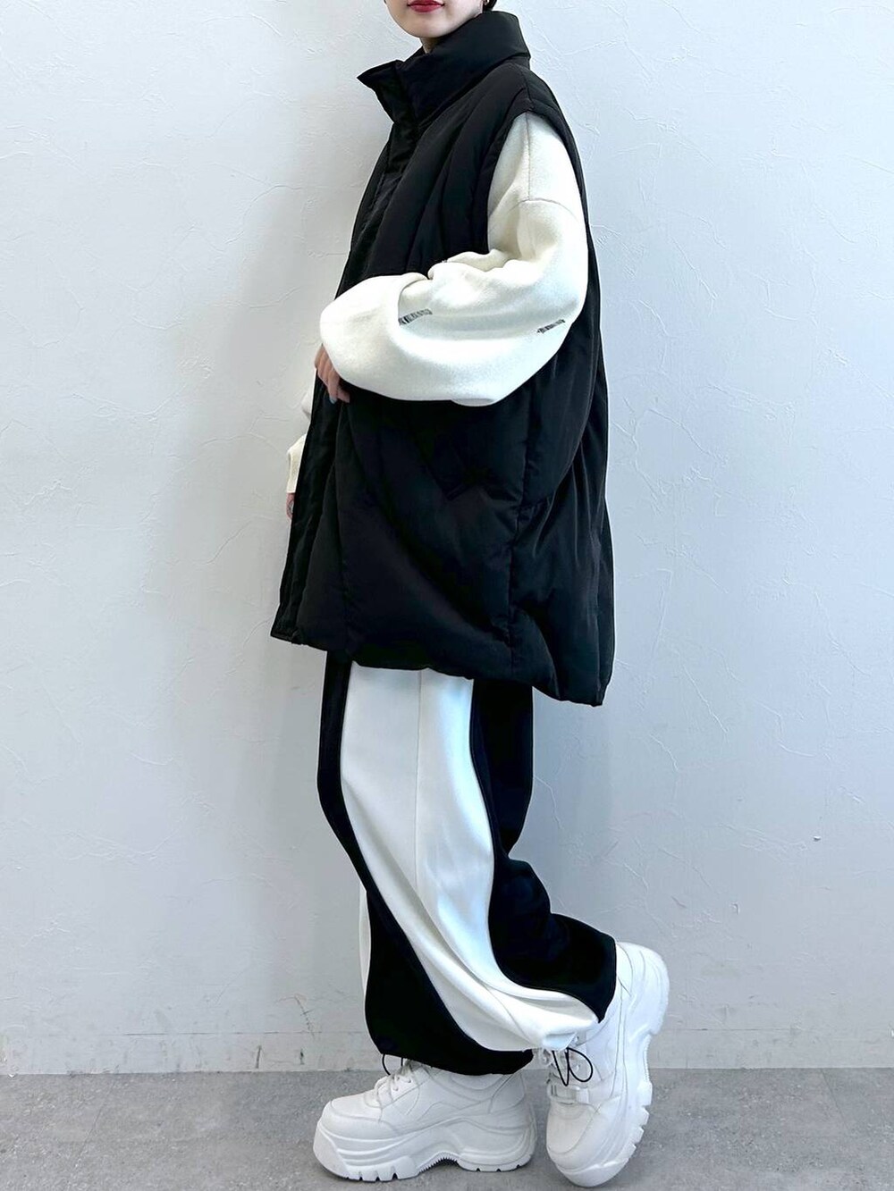 ブラック系のブルゾン、ブラック系のその他パンツ、ホワイト系のニット/セーターを着用したレディースの秋コーディネートの6枚目の写真