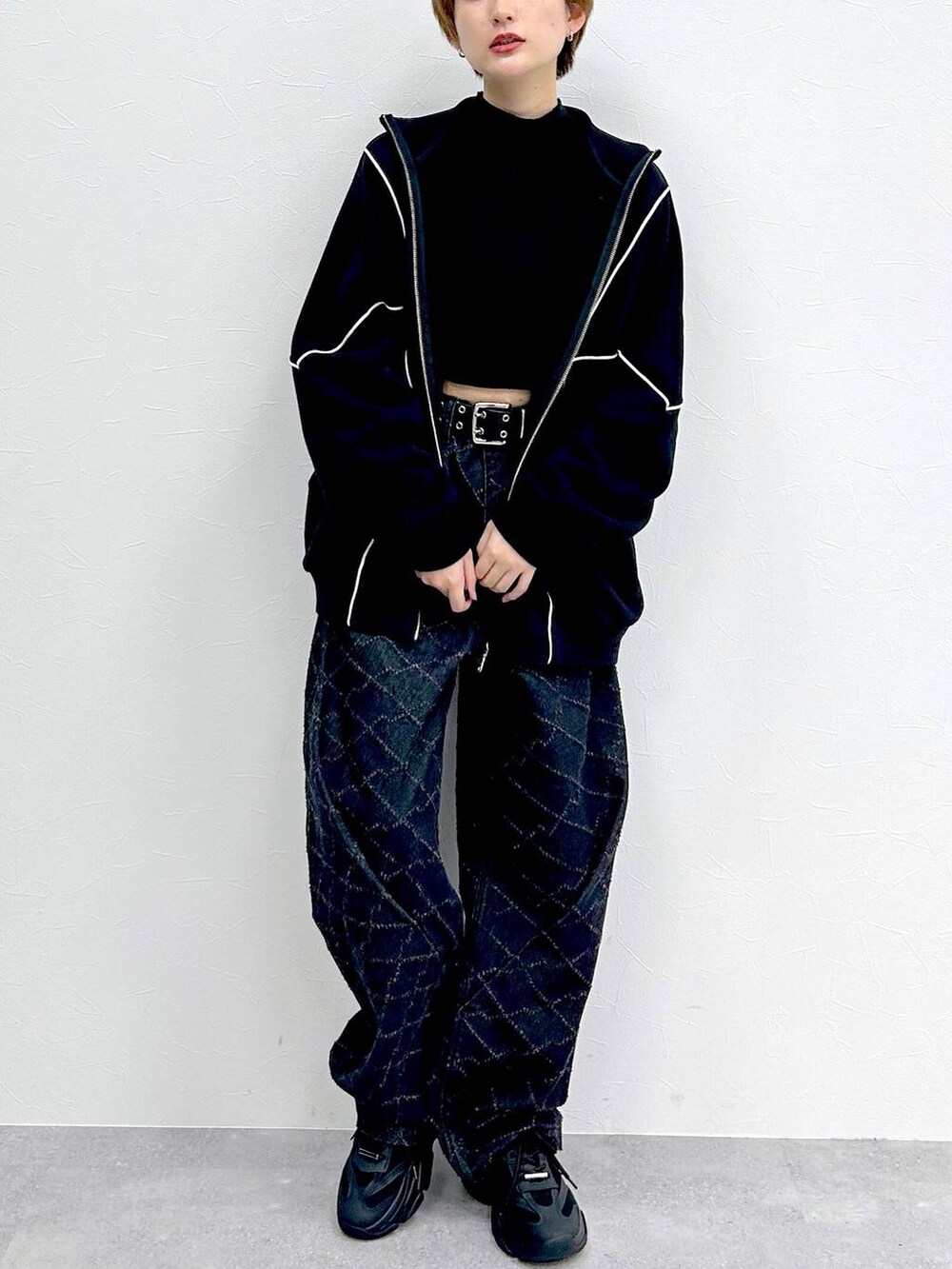 ブラック系のスウェット、ブラック系のデニムパンツ、ブラック系のベルトを着用したレディースの冬コーディネートの2枚目の写真