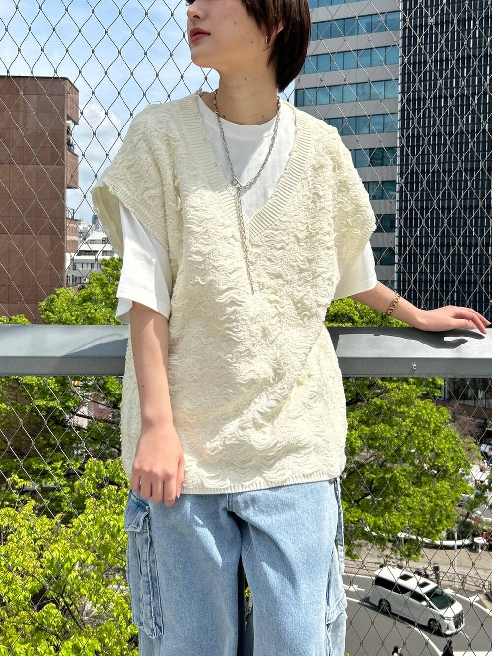 ホワイト系のベスト、ホワイト系のTシャツ/カットソー、ブルー系のデニムパンツを着用したレディースの夏コーディネートの9枚目の写真