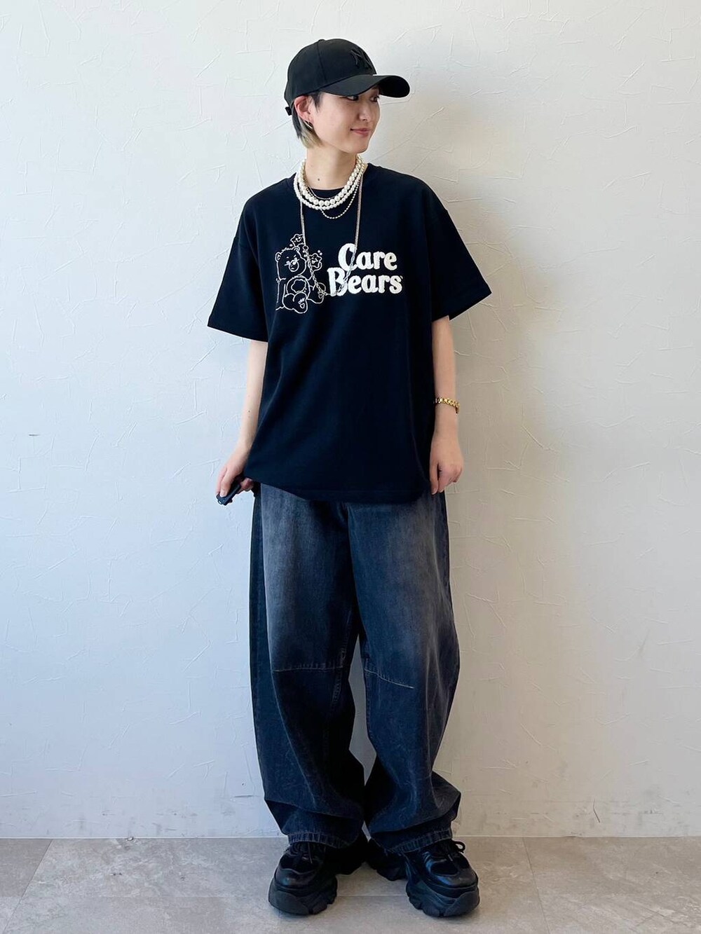 ブラック系のスニーカー、ブラック系のデニムパンツ、ブラック系のTシャツ/カットソーを着用したレディースの春コーディネートの2枚目の写真