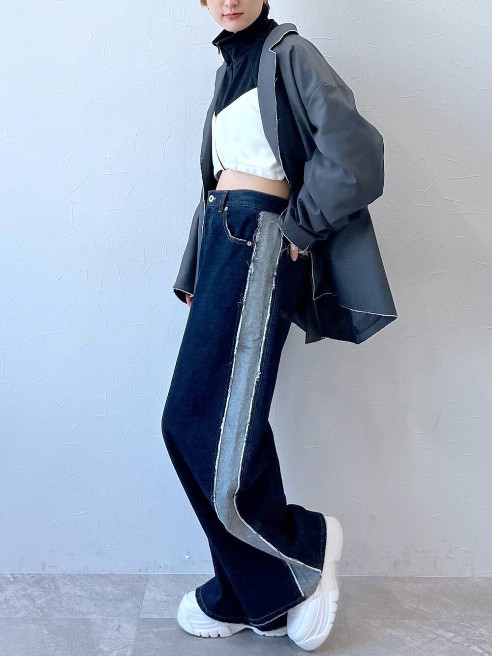 ブルー系のデニムパンツ、グレー系のテーラードジャケット、ブラック系のナイロンジャケットを着用したレディースの秋コーディネートの6枚目の写真