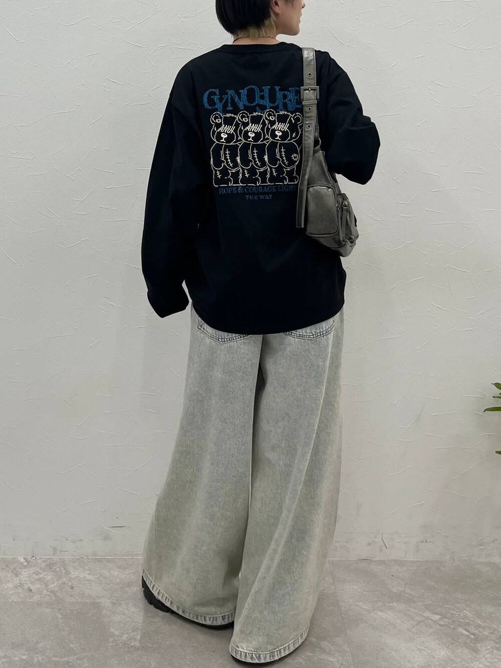 ブラック系のスニーカー、ブルー系のデニムパンツ、その他のショルダーバッグを着用したレディースの春コーディネートの2枚目の写真