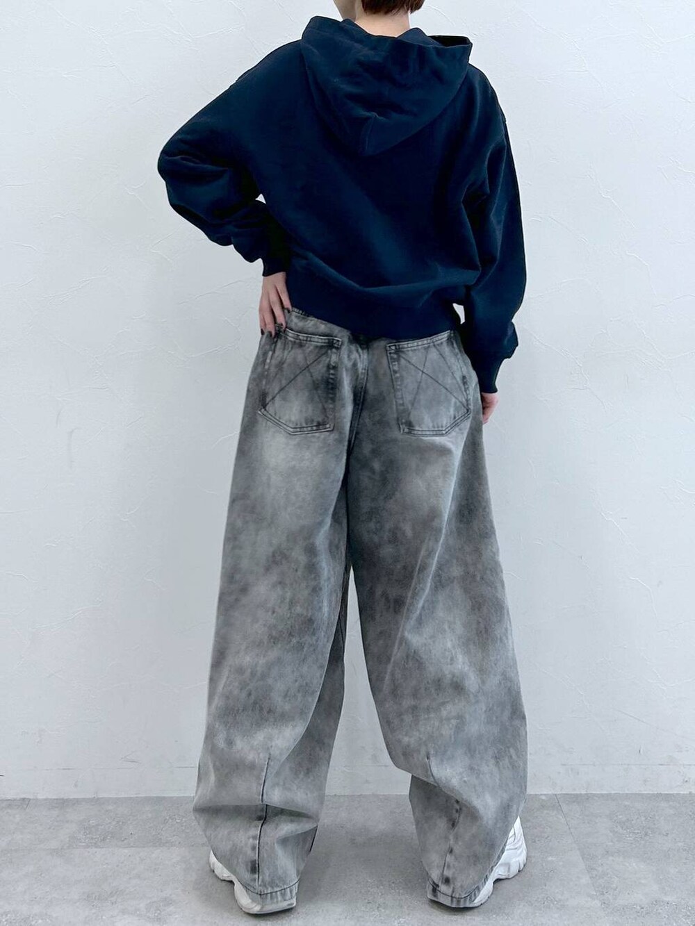 ブルー系のパーカー、ブラック系のデニムパンツを着用したレディースの春コーディネートの9枚目の写真