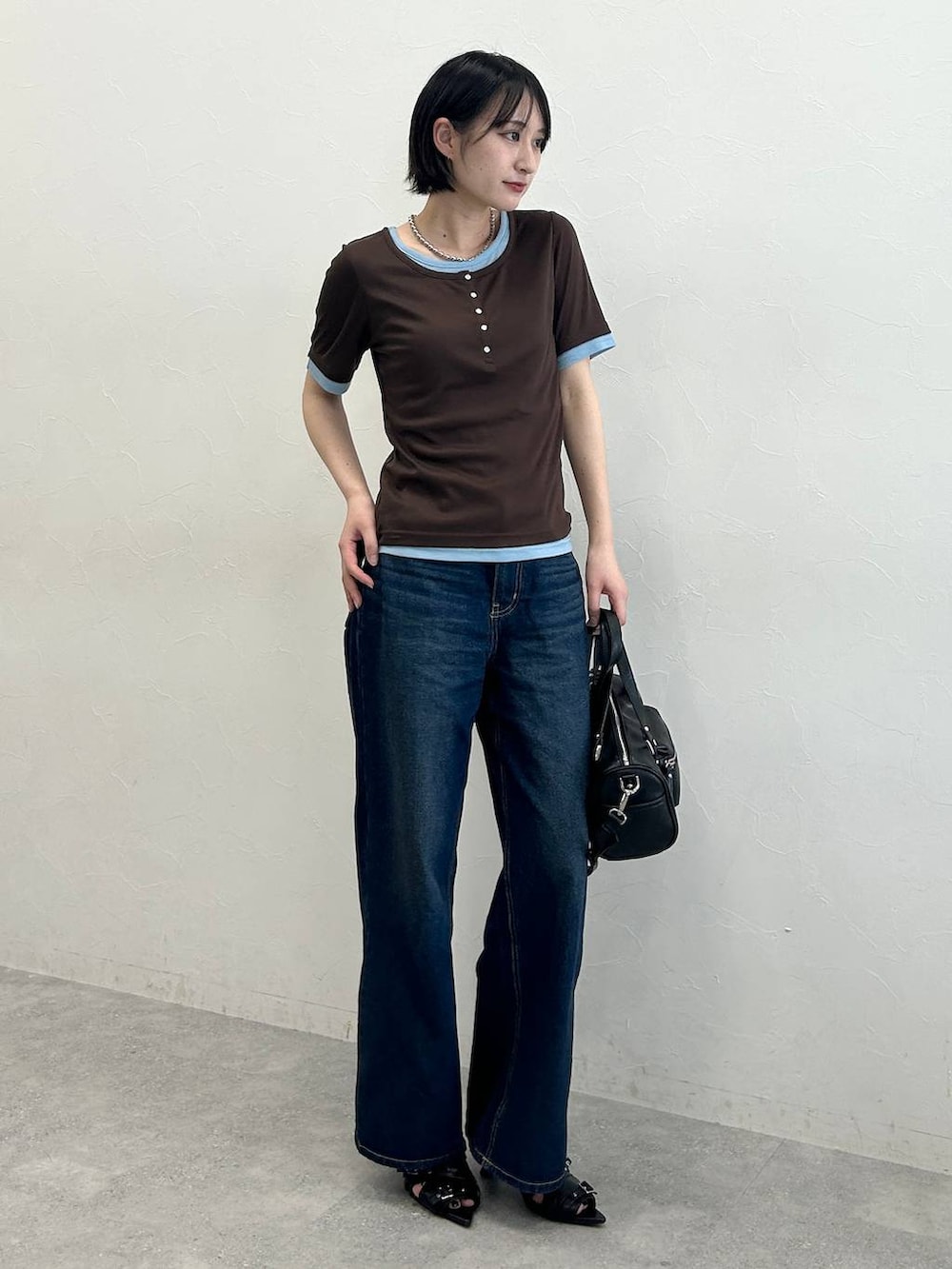 ブルー系のデニムパンツ、ブラック系のサンダル、ブラウン系のTシャツ/カットソーを着用したレディースの春コーディネートの3枚目の写真
