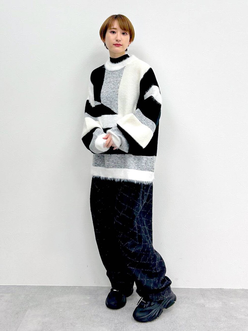 ブラック系のデニムパンツ、グレー系のニット/セーターを着用したレディースの冬コーディネートの3枚目の写真