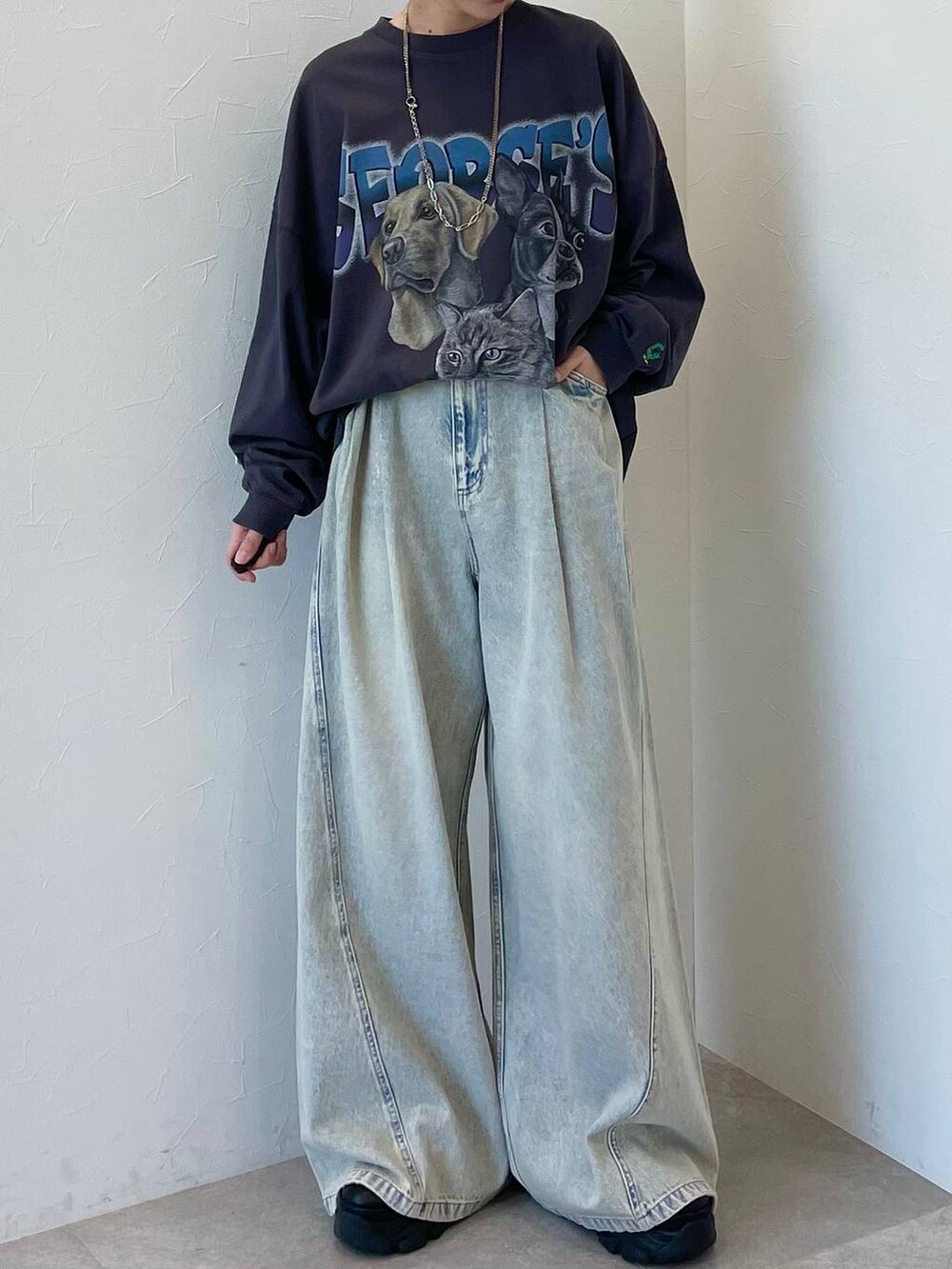 ブラック系のスニーカー、ブルー系のデニムパンツ、ブラック系のキャップを着用したレディースの春コーディネートの2枚目の写真