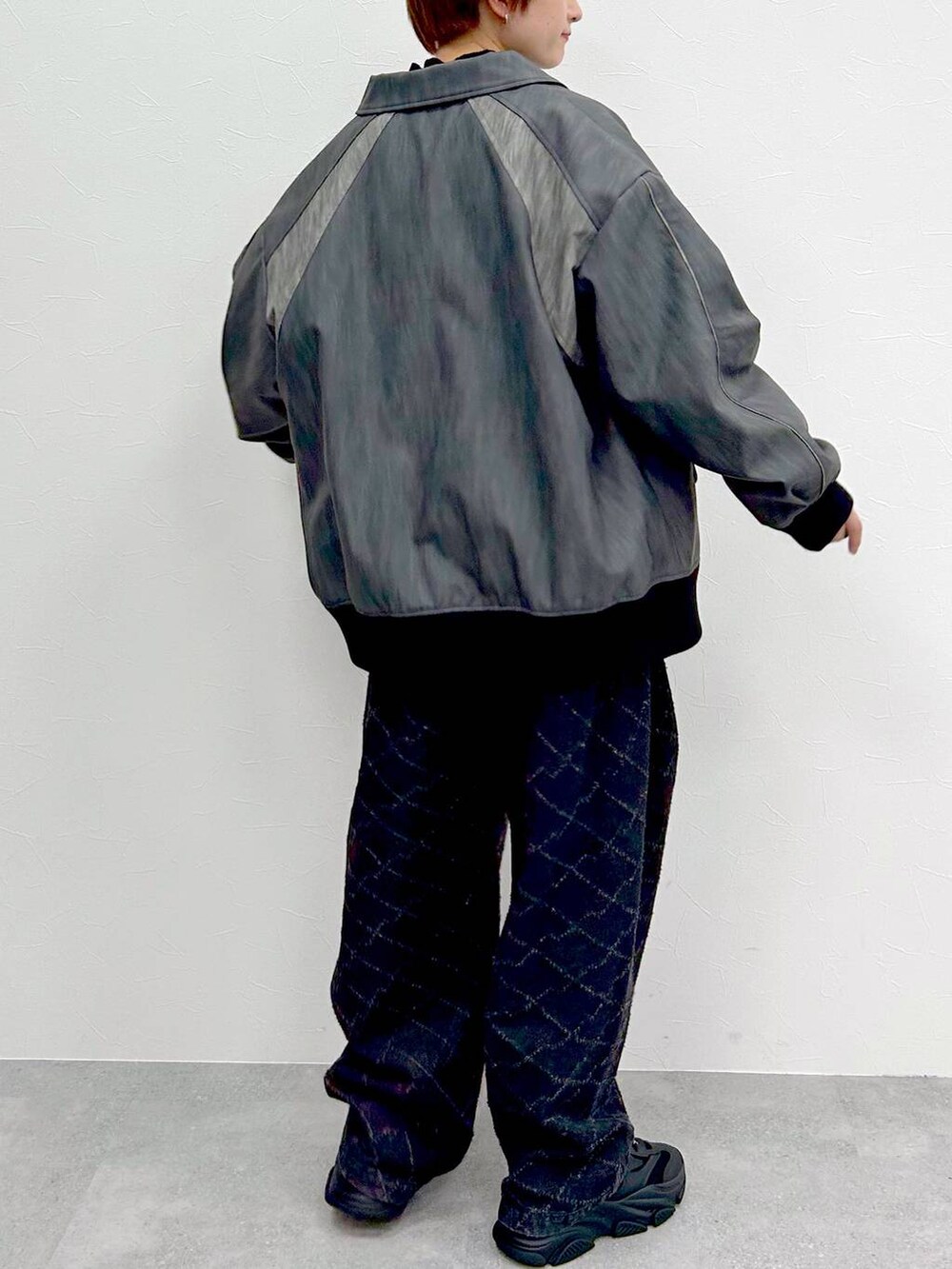 グレー系のブルゾン、ブラック系のデニムパンツ、グレー系のニット/セーターを着用したレディースの春コーディネートの8枚目の写真