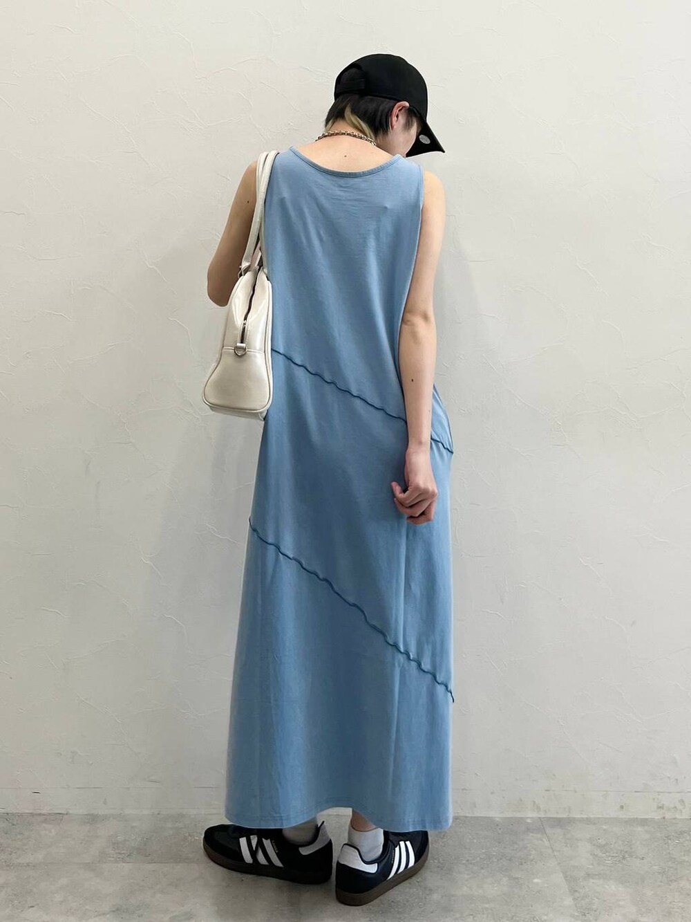 ホワイト系のボストンバッグ、ブラック系のスニーカー、ブルー系のワンピースを着用したレディースの春コーディネートの6枚目の写真