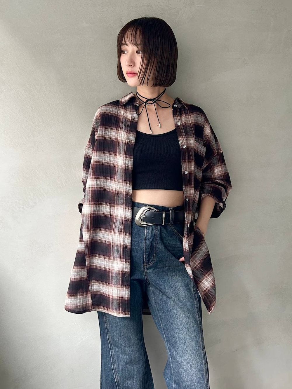 ブラック系のスニーカー、ブラック系のキャミソール、ブルー系のデニムパンツを着用したレディースの夏コーディネートの2枚目の写真