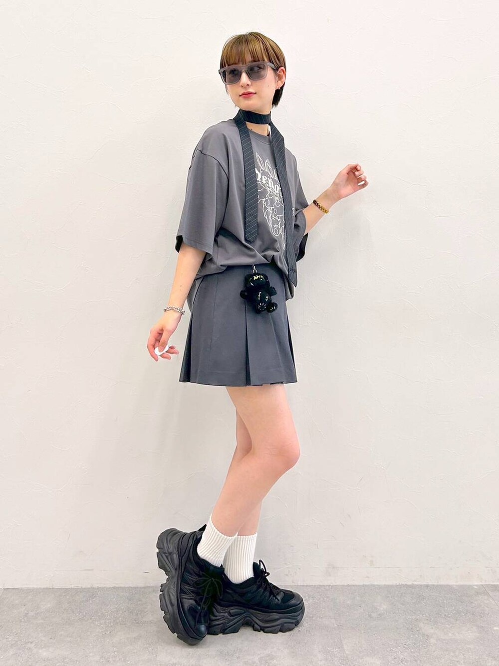 ブラック系のスニーカー、グレー系のTシャツ/カットソー、グレー系のネクタイを着用したレディースの夏コーディネートの4枚目の写真