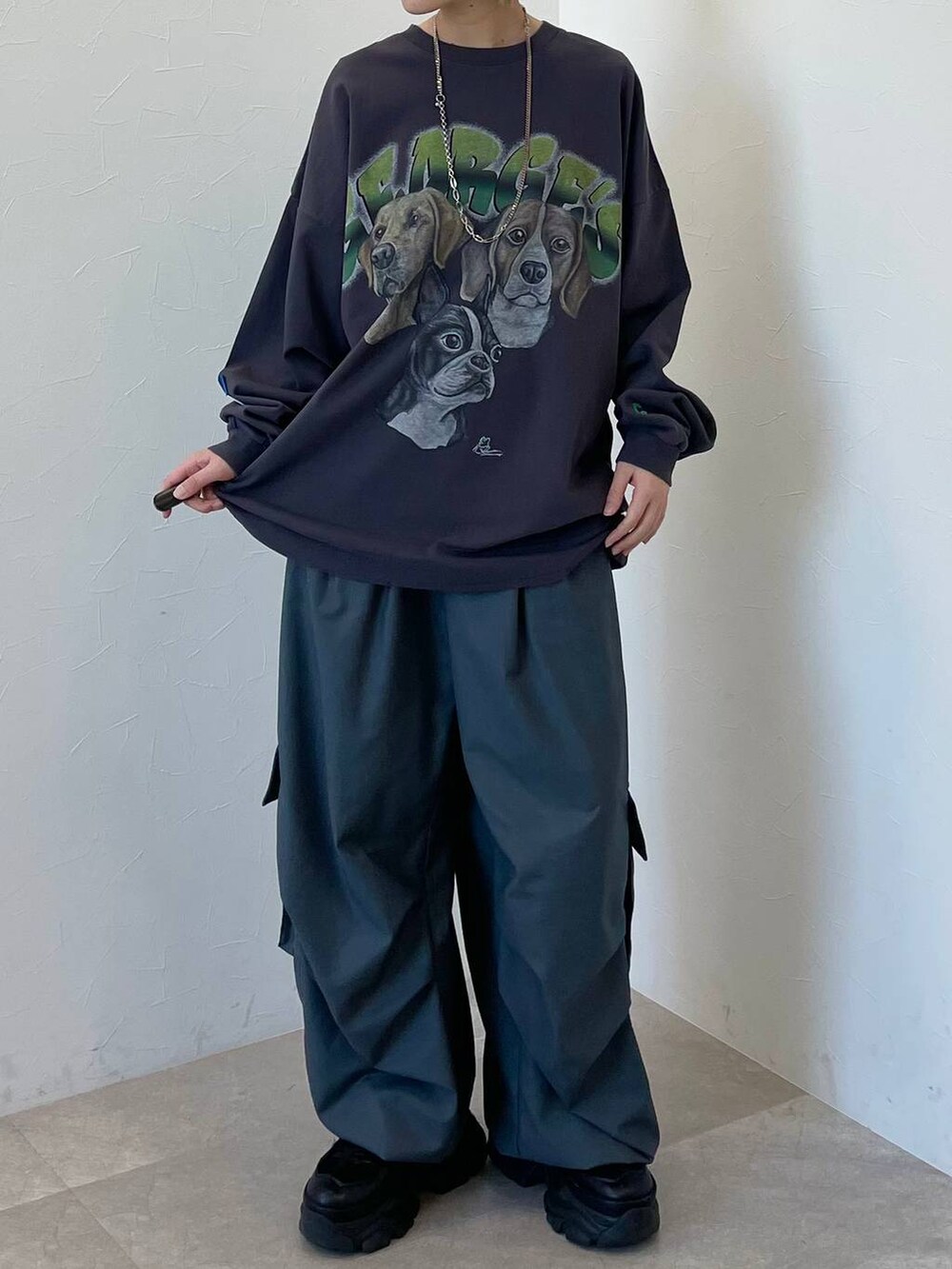 ブラック系のスニーカー、グレー系のカーゴパンツ、ブラック系のキャップを着用したレディースの春コーディネートの2枚目の写真