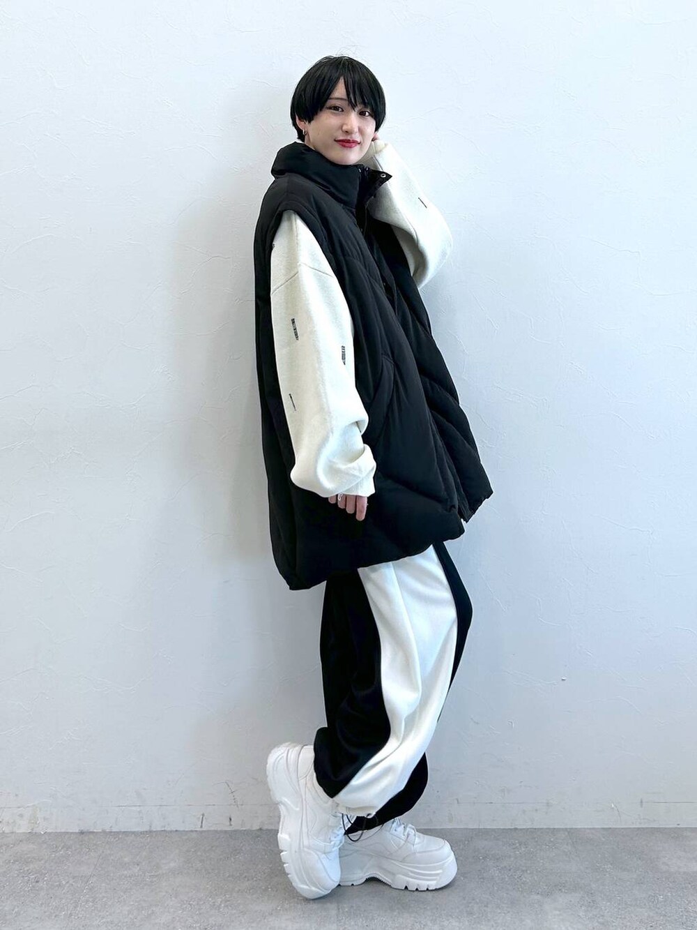 ブラック系のブルゾン、ブラック系のその他パンツ、ホワイト系のニット/セーターを着用したレディースの秋コーディネートの4枚目の写真