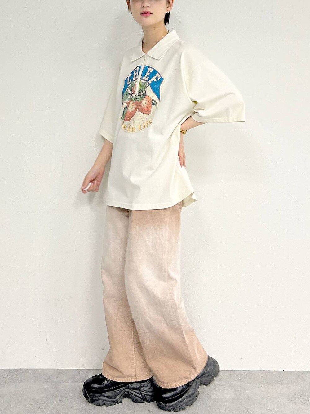 ピンク系のデニムパンツ、ブラック系のスニーカー、ホワイト系のTシャツ/カットソーを着用したレディースの夏コーディネートの4枚目の写真