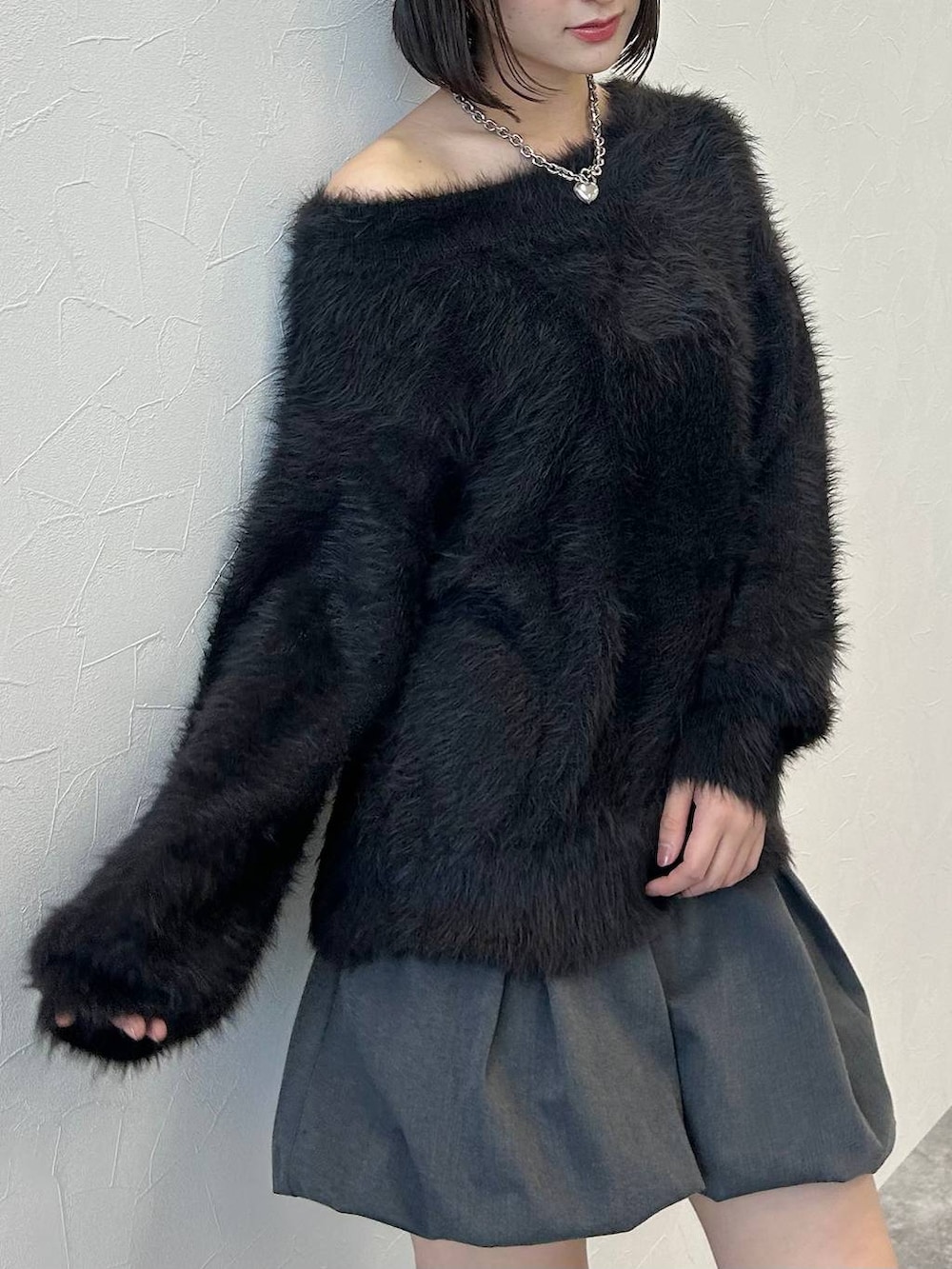 ブラック系のニット/セーター、シルバー系のネックレスを着用したレディースの秋コーディネートの9枚目の写真