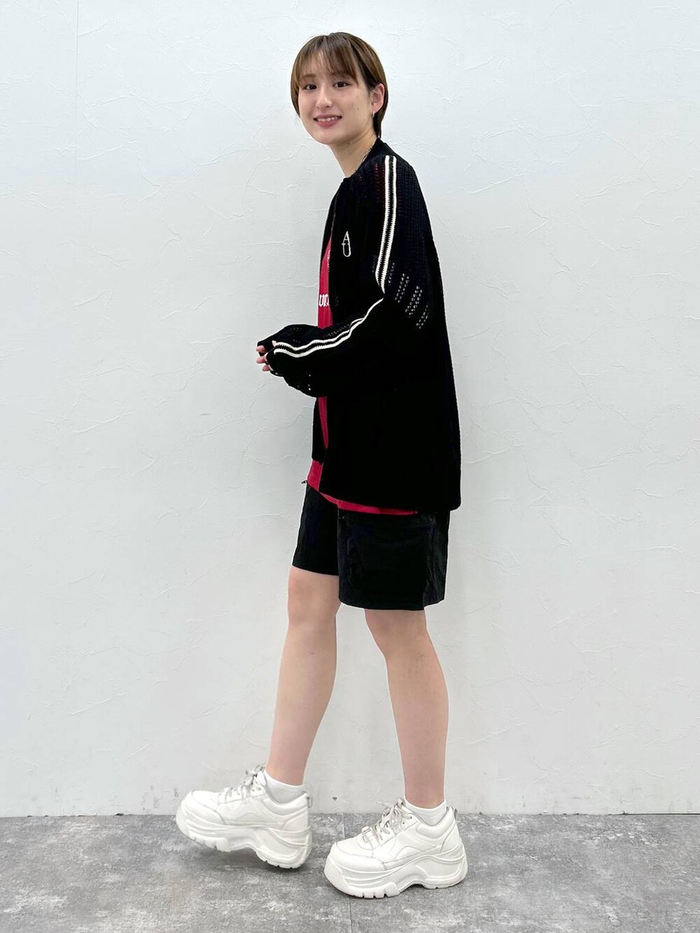 ブラック系のカーディガン/ボレロ、レッド系のTシャツ/カットソー、ブラック系のカーゴパンツを着用したレディースの春コーディネートの3枚目の写真