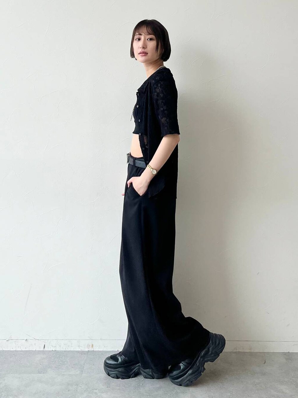 ブラック系のスニーカー、ブラック系のキャミソール、ブラック系のスラックスを着用したレディースの夏コーディネートの5枚目の写真