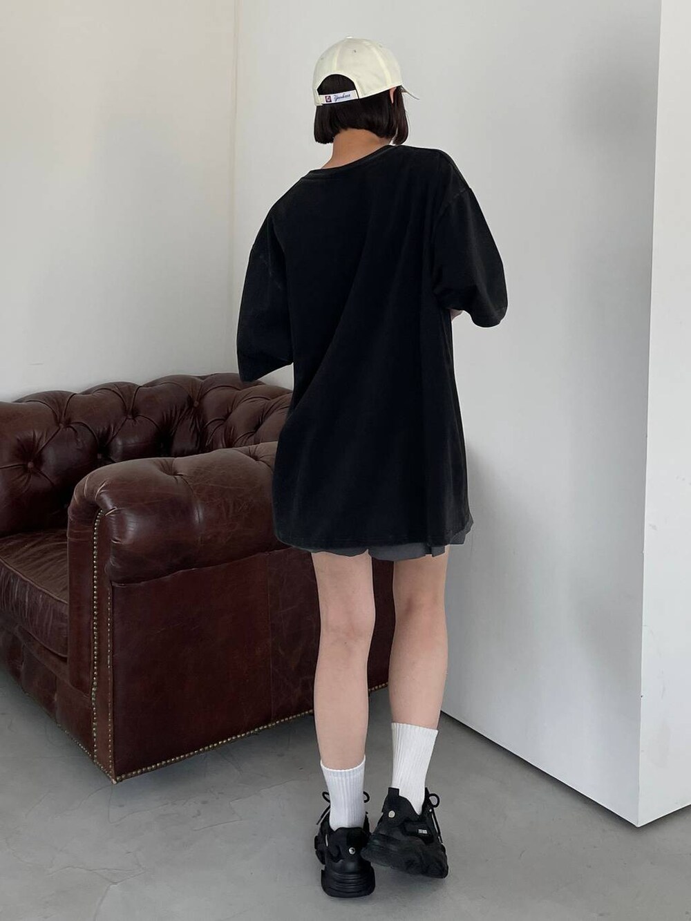 ブラック系のTシャツ/カットソー、ホワイト系のキャップを着用したレディースの夏コーディネートの7枚目の写真