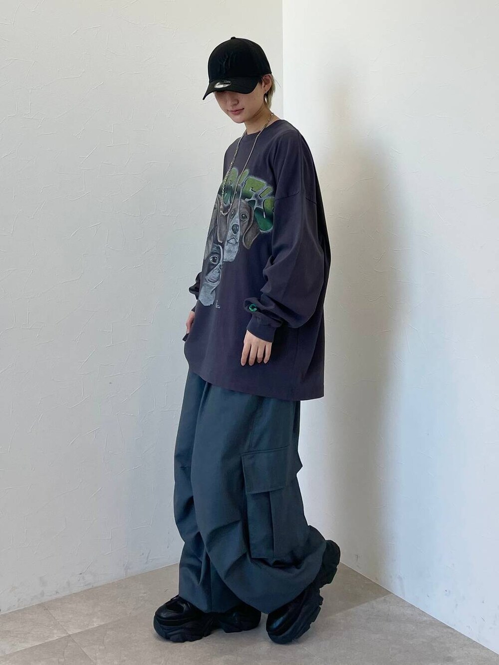 ブラック系のスニーカー、グレー系のカーゴパンツ、ブラック系のキャップを着用したレディースの春コーディネートの3枚目の写真