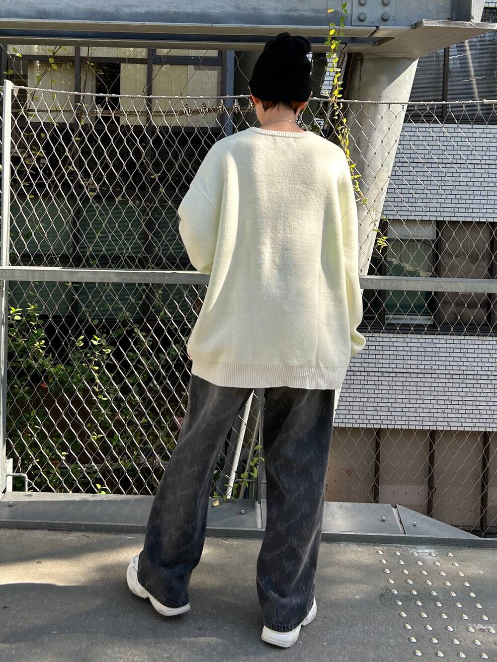 ブラック系のデニムパンツ、ホワイト系のニット/セーター、ブラック系のニットキャップ/ビーニーを着用したレディースの冬コーディネートの7枚目の写真