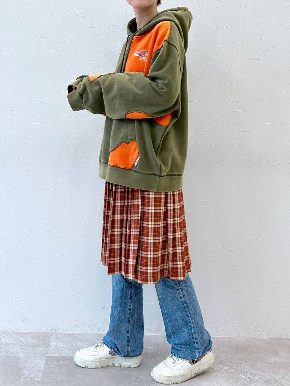 グリーン系のパーカー、レッド系のスカートを着用したレディースの秋コーディネートの2枚目の写真