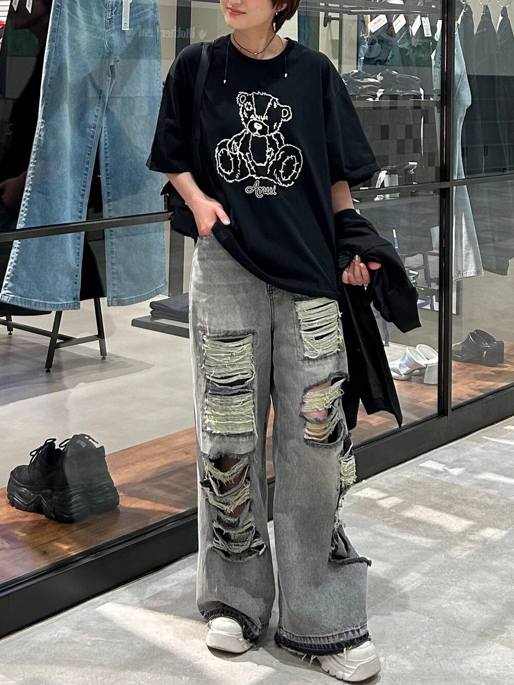 ブラック系のショルダーバッグ、ブラック系のテーラードジャケット、ブラック系のデニムパンツを着用したレディースの春コーディネートの2枚目の写真