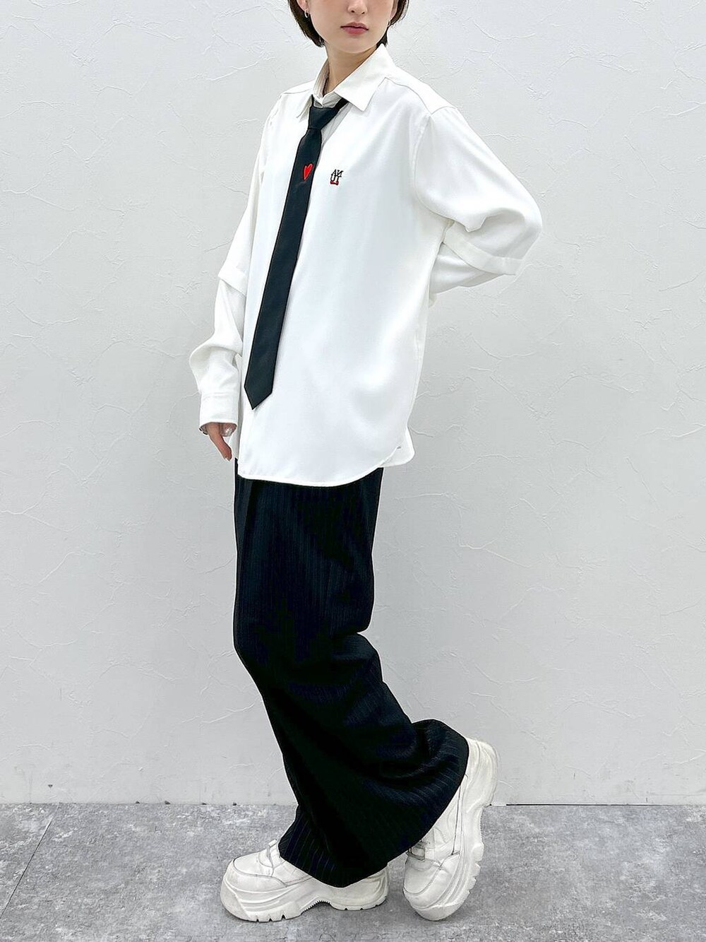 ブラック系のネクタイ、ホワイト系のシャツ/ブラウス、ブラック系のスラックスを着用したレディースの春コーディネートの4枚目の写真