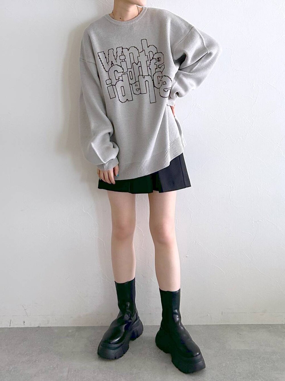 ブラック系のブーツ、ブラック系のその他パンツ、グレー系のニット/セーターを着用したレディースの冬コーディネートの2枚目の写真