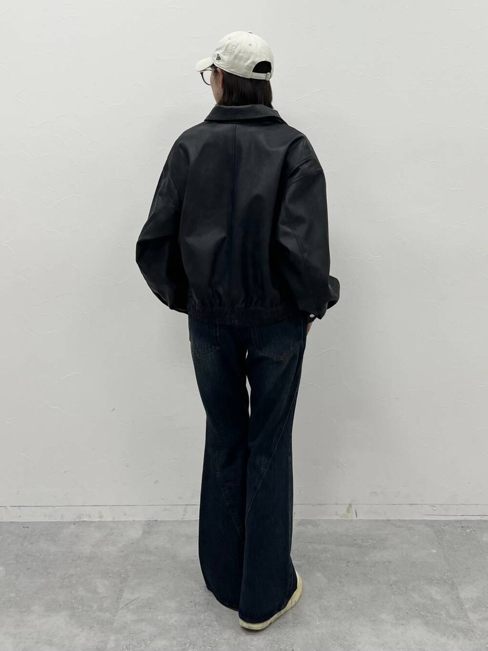 ブルー系のデニムパンツ、ブラック系のブルゾン、ブラック系のTシャツ/カットソーを着用したレディースの夏コーディネートの6枚目の写真