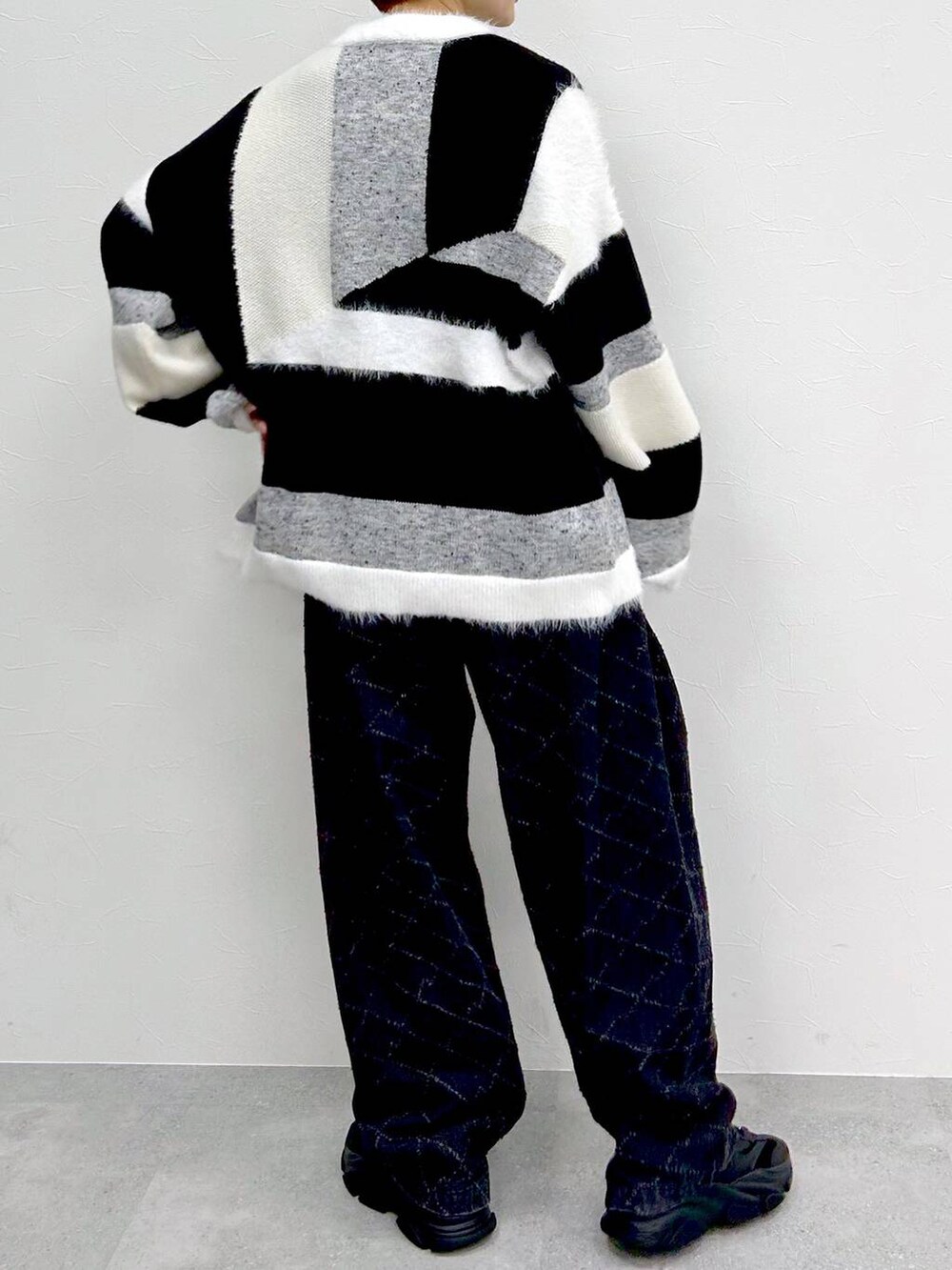 ブラック系のデニムパンツ、グレー系のニット/セーターを着用したレディースの冬コーディネートの8枚目の写真