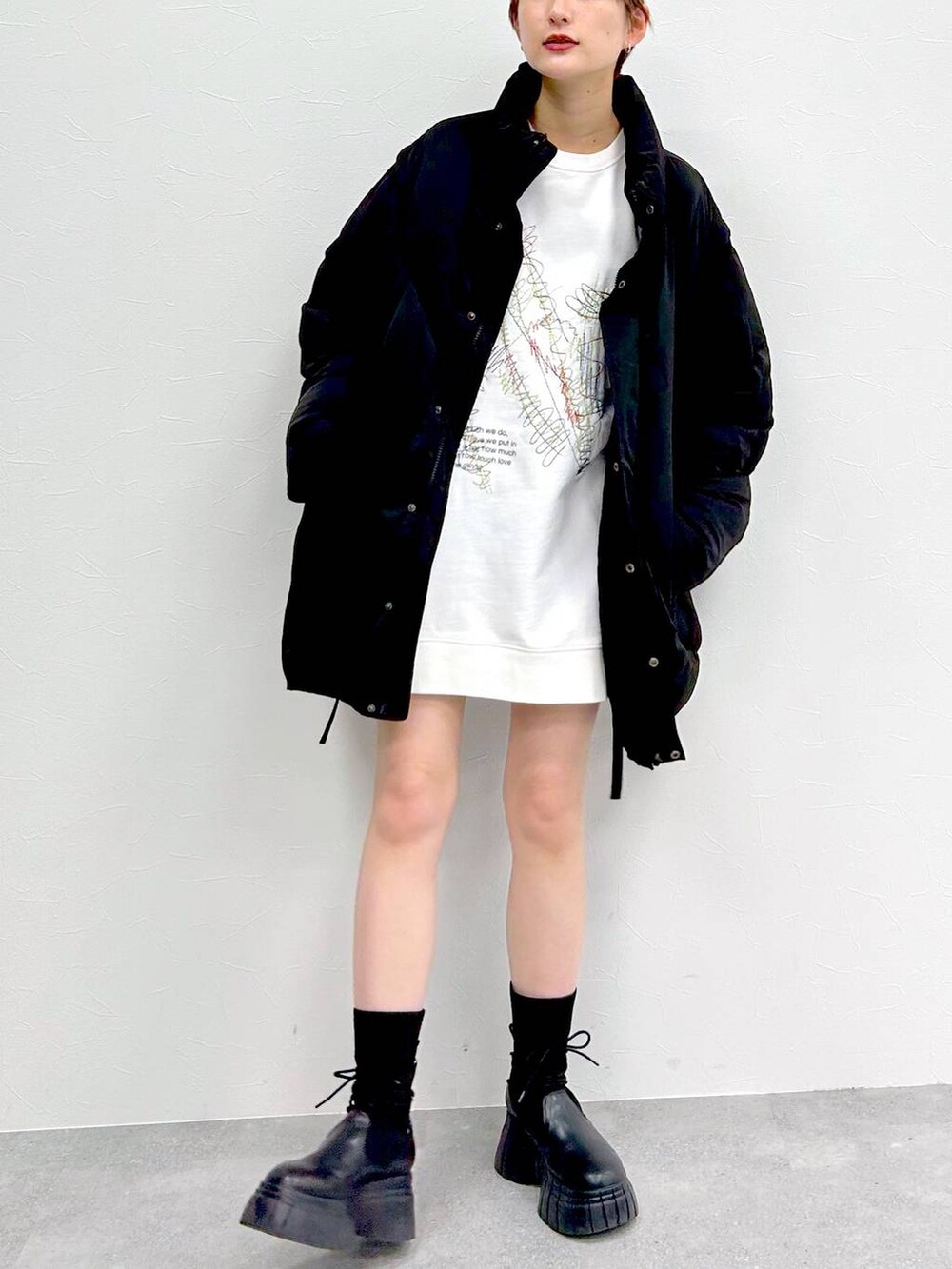 ブラック系のブルゾン、ブラック系のブーツ、ブラック系のスカートを着用したレディースの冬コーディネートの3枚目の写真