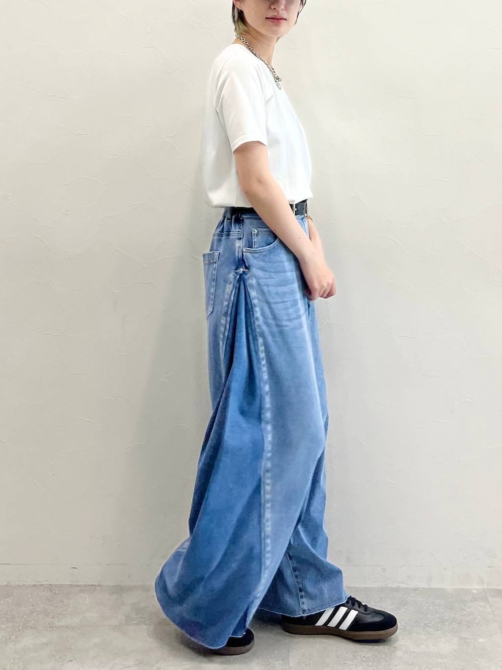 ブラック系のキャミソール、ブラック系のスニーカー、ブルー系のデニムパンツを着用したレディースの春コーディネートの3枚目の写真