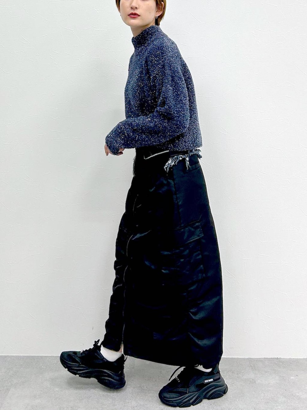 ブルー系のニット/セーター、ブラック系のスカートを着用したレディースの冬コーディネートの4枚目の写真