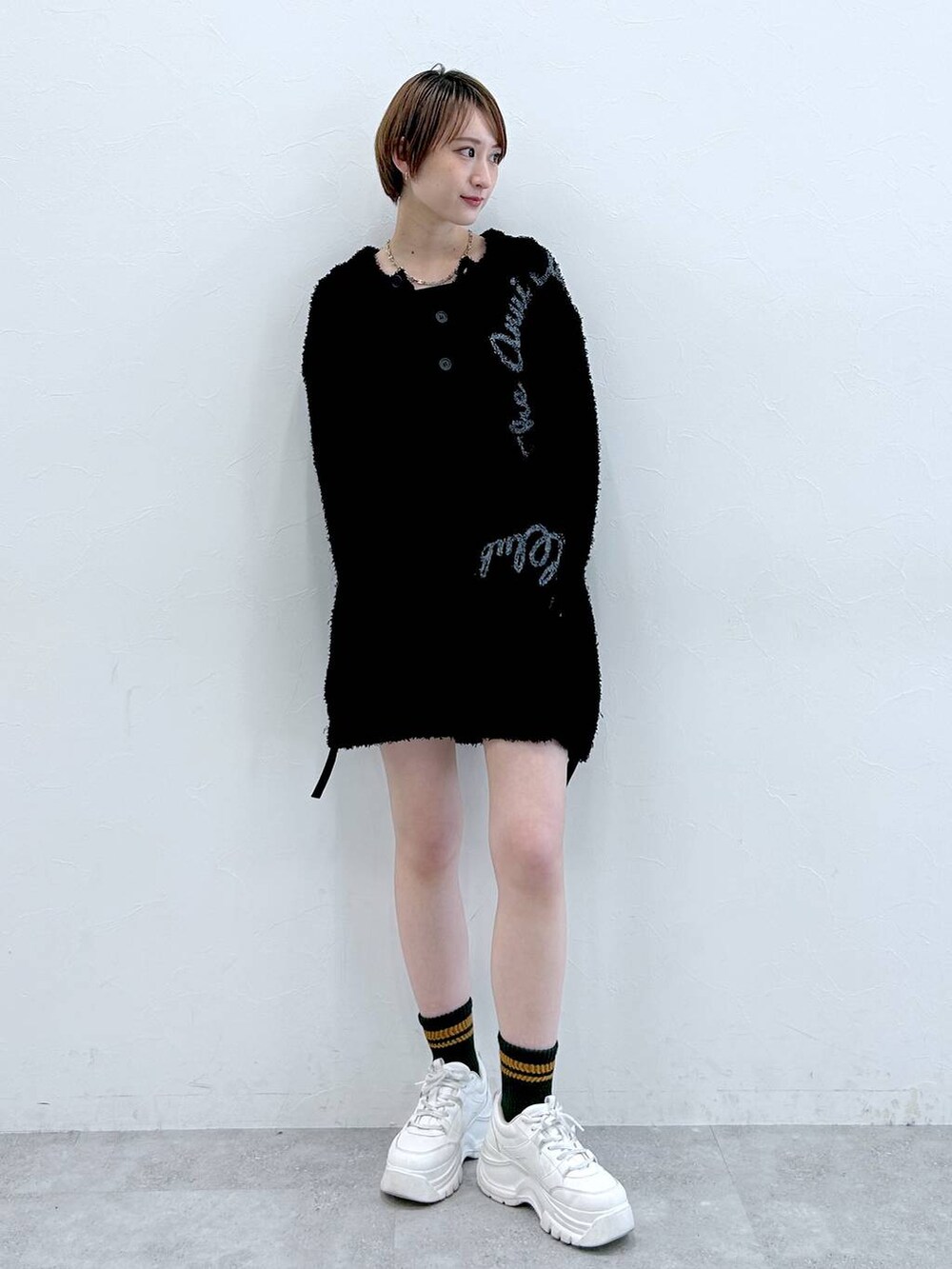 ブラック系のニット/セーターを着用したレディースの春コーディネートの2枚目の写真