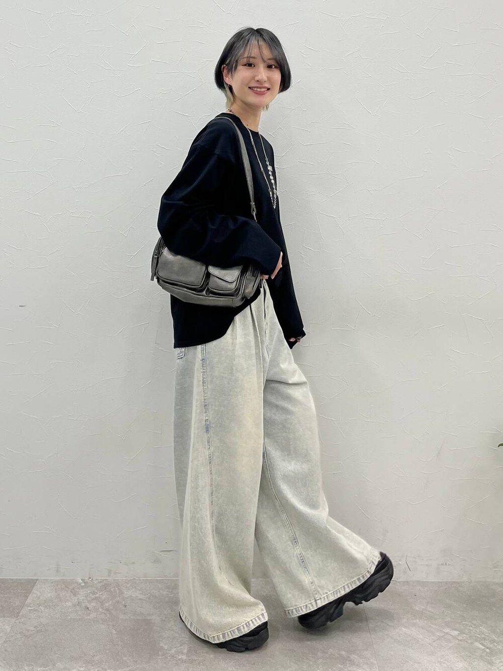ブラック系のスニーカー、ブルー系のデニムパンツ、その他のショルダーバッグを着用したレディースの春コーディネートの5枚目の写真