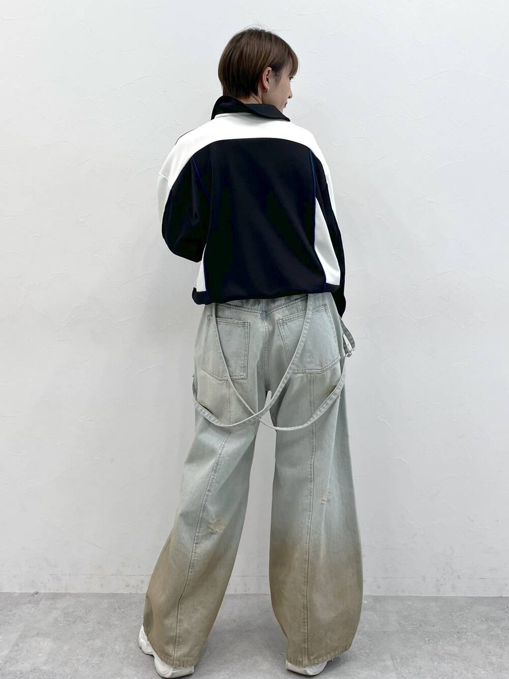 ブラック系のポロシャツ、ブルー系のデニムパンツを着用したレディースの春コーディネートの6枚目の写真