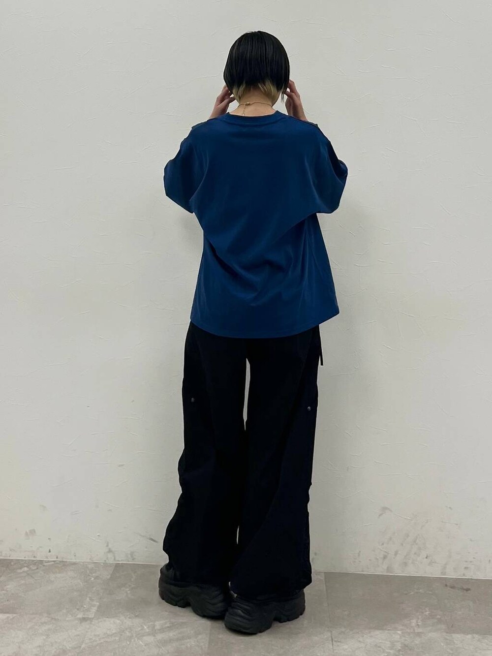 ブラック系のスニーカー、ブルー系のTシャツ/カットソー、ブラック系のカーゴパンツを着用したレディースの春コーディネートの6枚目の写真