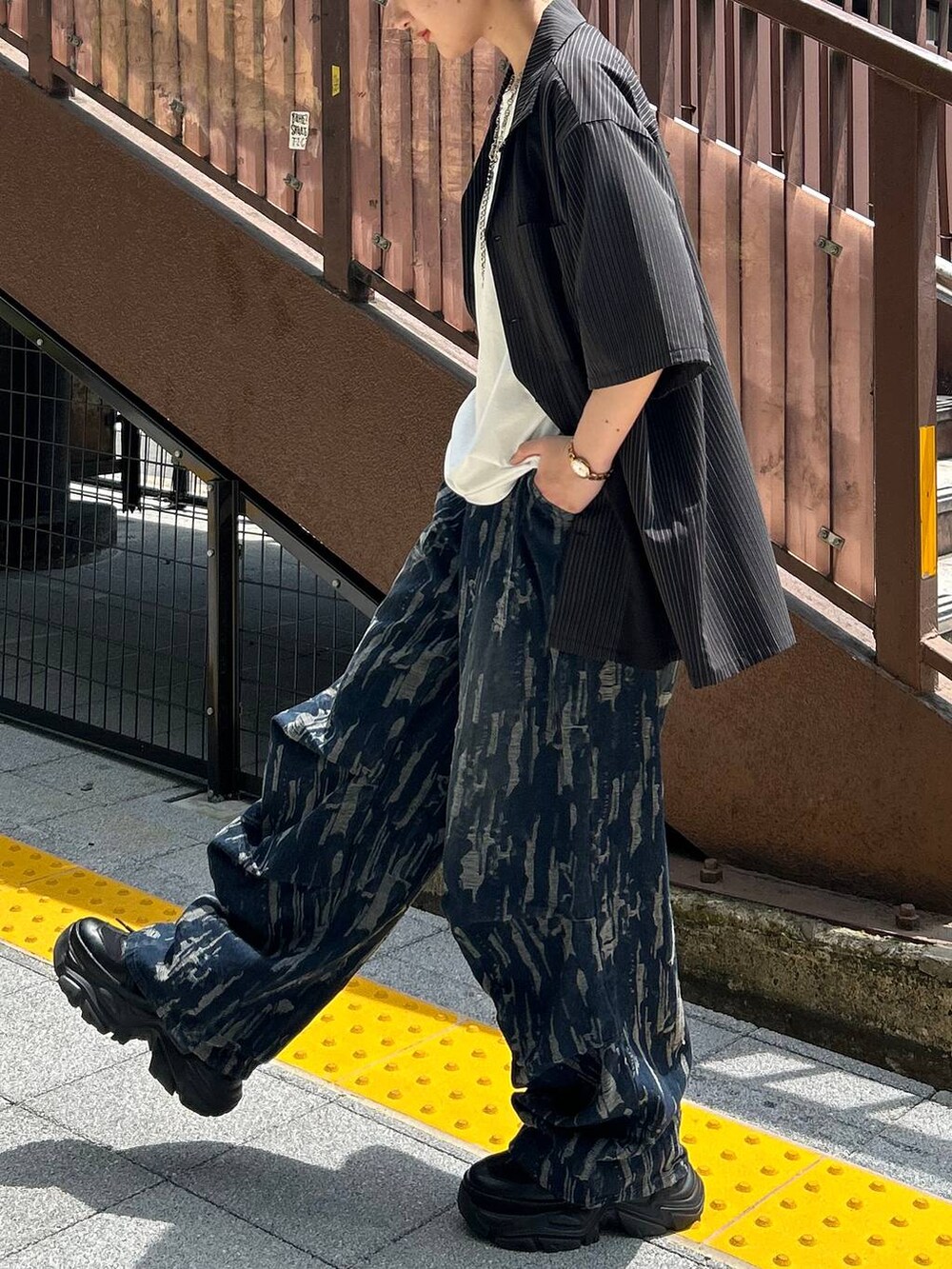 ブラック系のスニーカー、ホワイト系のTシャツ/カットソー、ブラック系のシャツ/ブラウスを着用したレディースの秋コーディネートの4枚目の写真