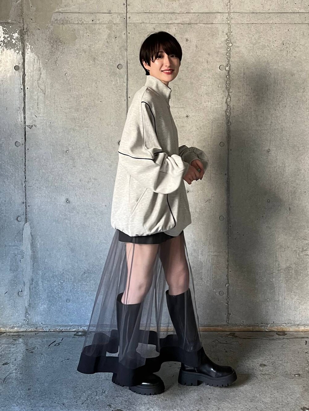 ブラック系のブーツ、グレー系のスウェット、グレー系のスカートを着用したレディースの冬コーディネートの3枚目の写真