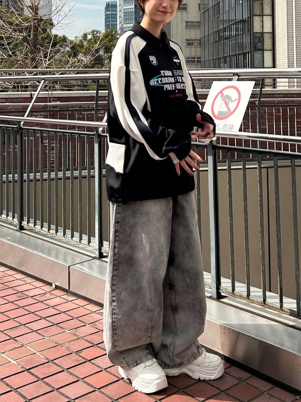 ブラック系のポロシャツ、ブラック系のデニムパンツを着用したレディースの春コーディネートの6枚目の写真