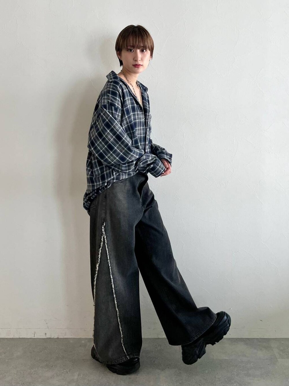 ブラック系のスニーカー、ブルー系のシャツ/ブラウス、ブラック系のデニムパンツを着用したレディースの秋コーディネートの3枚目の写真