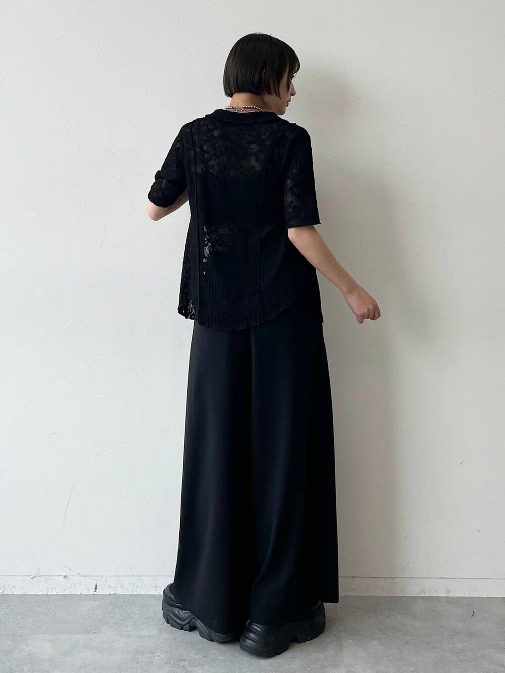 ブラック系のスニーカー、ブラック系のキャミソール、ブラック系のスラックスを着用したレディースの夏コーディネートの7枚目の写真